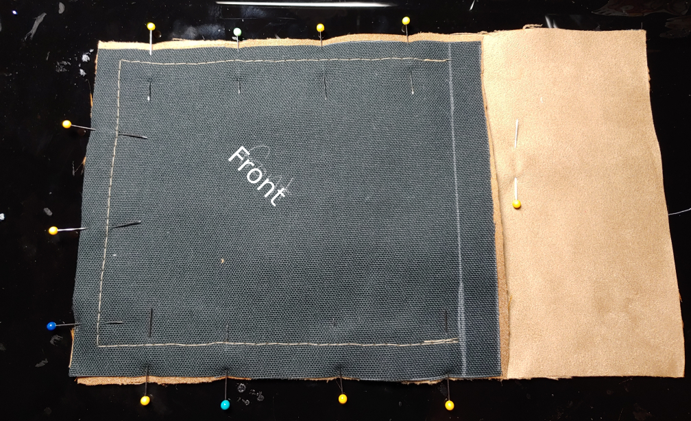 Front and back pieces sewn together. The stitches stop at the line drawn earlier across the top of the phone. The fabric is labeled front