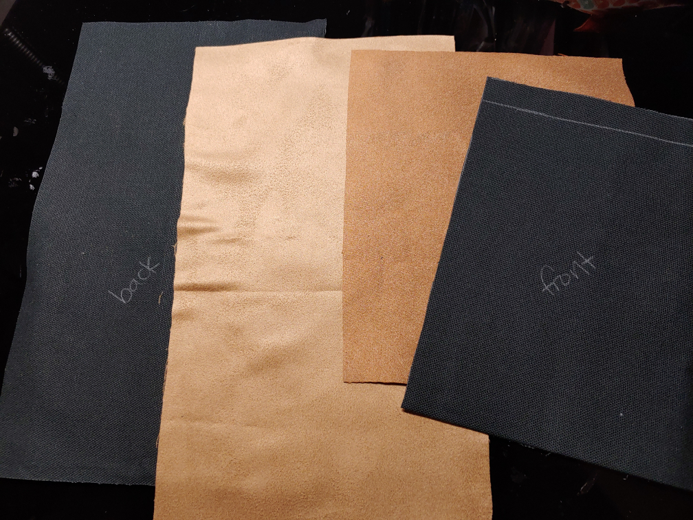 Canvas and faux suede pieces cut out. The canvas is in black while the faux suede is a light beige.