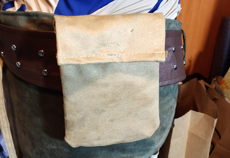 a beige faux suede belt pouch sits attached to a thick brown belt