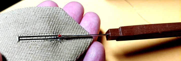 Pushing the seam ripper through the fabric. Buttonhole has been outlined in black