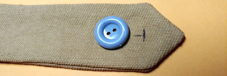 The start of a buttonhole marked sitting next to a button