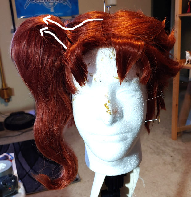Arrows swoop to the left side to indicate how fibers from the top and front of the wig are pulled back and glued down onto the pillow