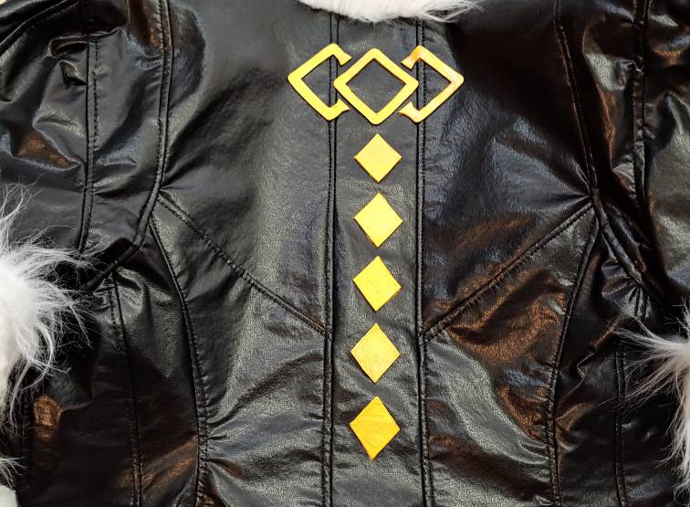 A gold diamond design made out of foamies glued to the back of a black jacket
