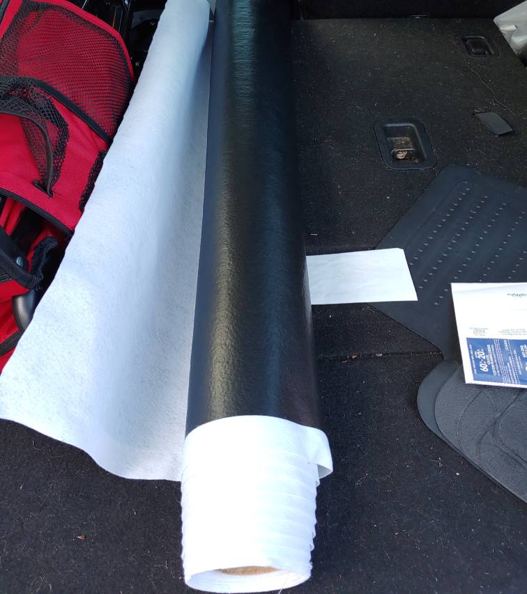 A roll of vinyl on a cardboard tube sitting in the back of my car