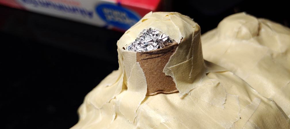 Vertebra bump made of toilet paper and foil partially taped down