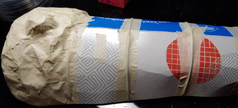 First section with foil volume completely taped down. the section on the right is covered with beige masking tape and features a prominent bump in the middle