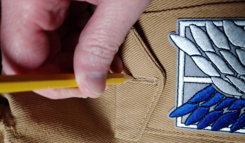 Marking the buttonhole position with a pencil. The pocket flap is closed while marking the buttonhole with a pencil.