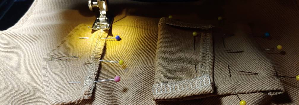 Sewing the flap with the pocket rolled down. The pocket (right) is pinned back while sewing the flap (left)