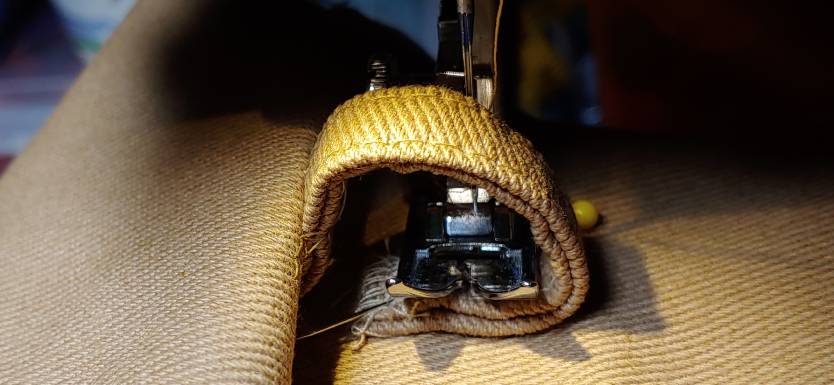 Pushing the fabric over so you can fit the foot inside the loop. the fabric on the left is pushed up to create a wide ring with the carrier. The foot fits inside the ring.