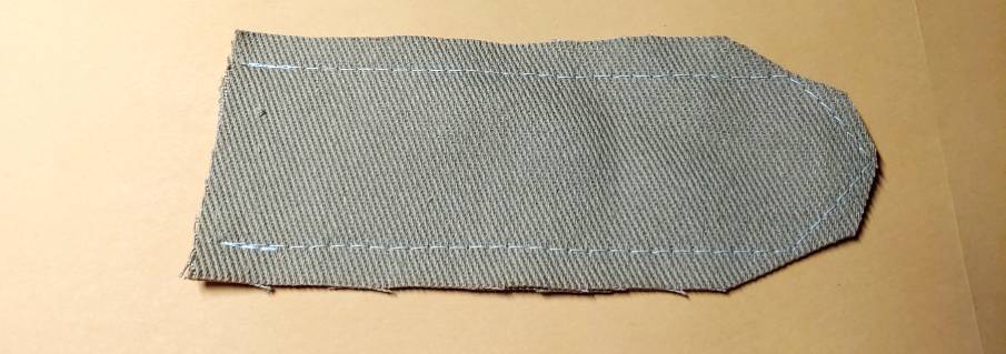 Shoulder tab sewn at a 3/8" seam allowance. the three corners on the tab are clipped to reduce the amount of fabric in the points when the tab is turned right-side out