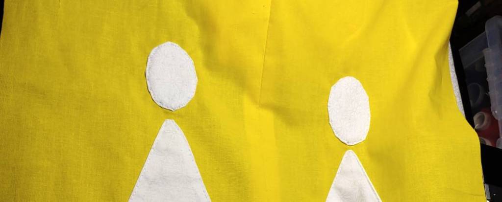 Two appliqued white circles on yellow fabric