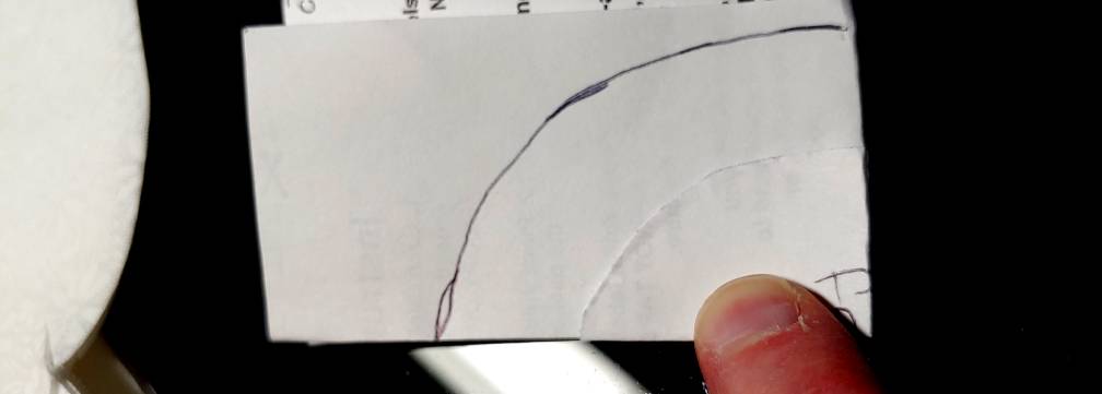 Matching the two folded papers up to make a second, larger circle pattern. The larger pattern is marked in black ink.