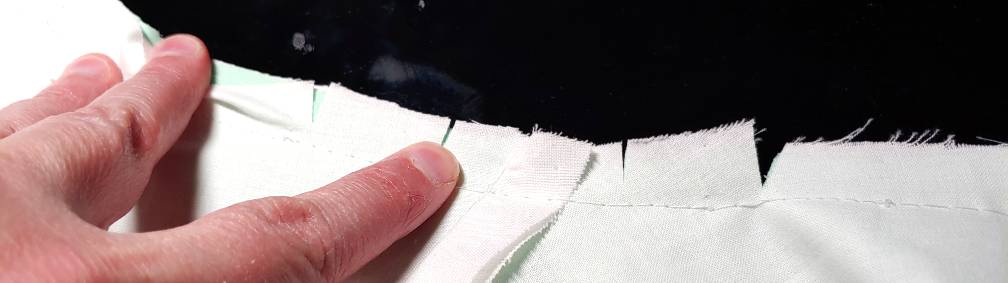 The curve of the collar clipped around the shoulder seam