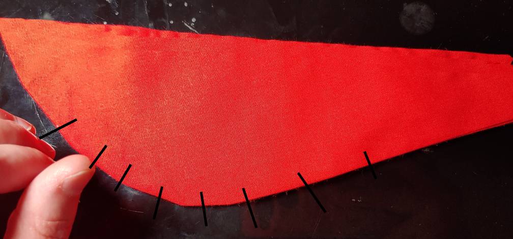 Scarf piece showing where to clip the curve. Clip marks are marked in black along the curved bottom edge.