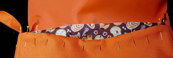 Body flipped right side out with the edges ironed and pinned. The brown cat bread fabric is peeking out at the center of the photo