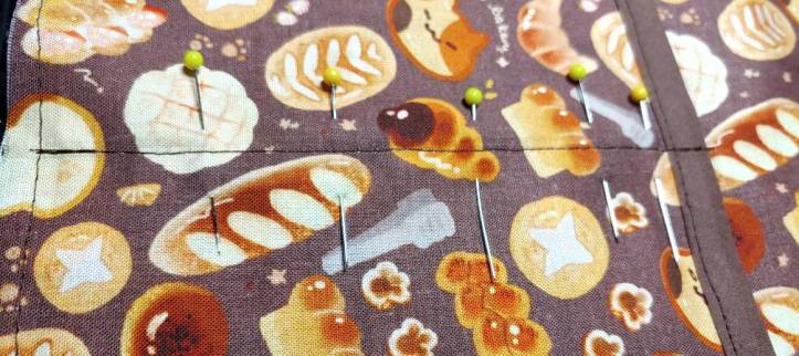 Separator line sewn in the pocket. Pins are placed along the line to secure it while sewing.