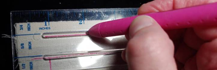 Adding a 5/8" seam allowance using a tailor's ruler. The ruler has guidelines cut out of the plastic to make drawing seam allowances simple.