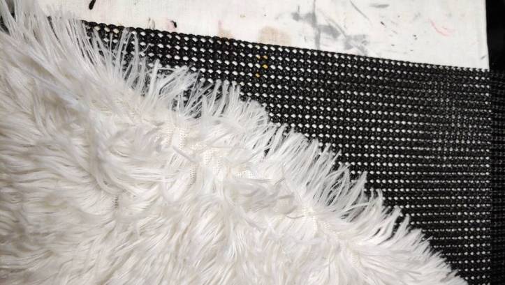 White fur wrap sitting on top of the black shelf liner