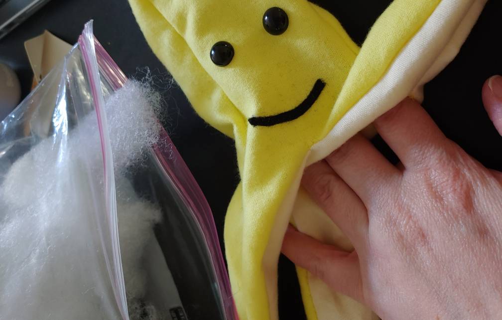 Stuffing a Mario Kart banana with fiberfill. Sometimes I partition the fiberfill out into bags so I don't drag the 5lb box around