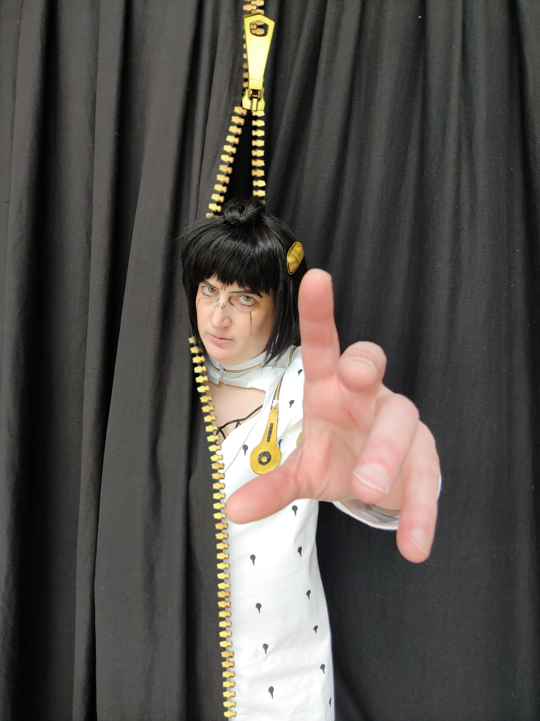 Bruno reaching forward through a zippered curtain