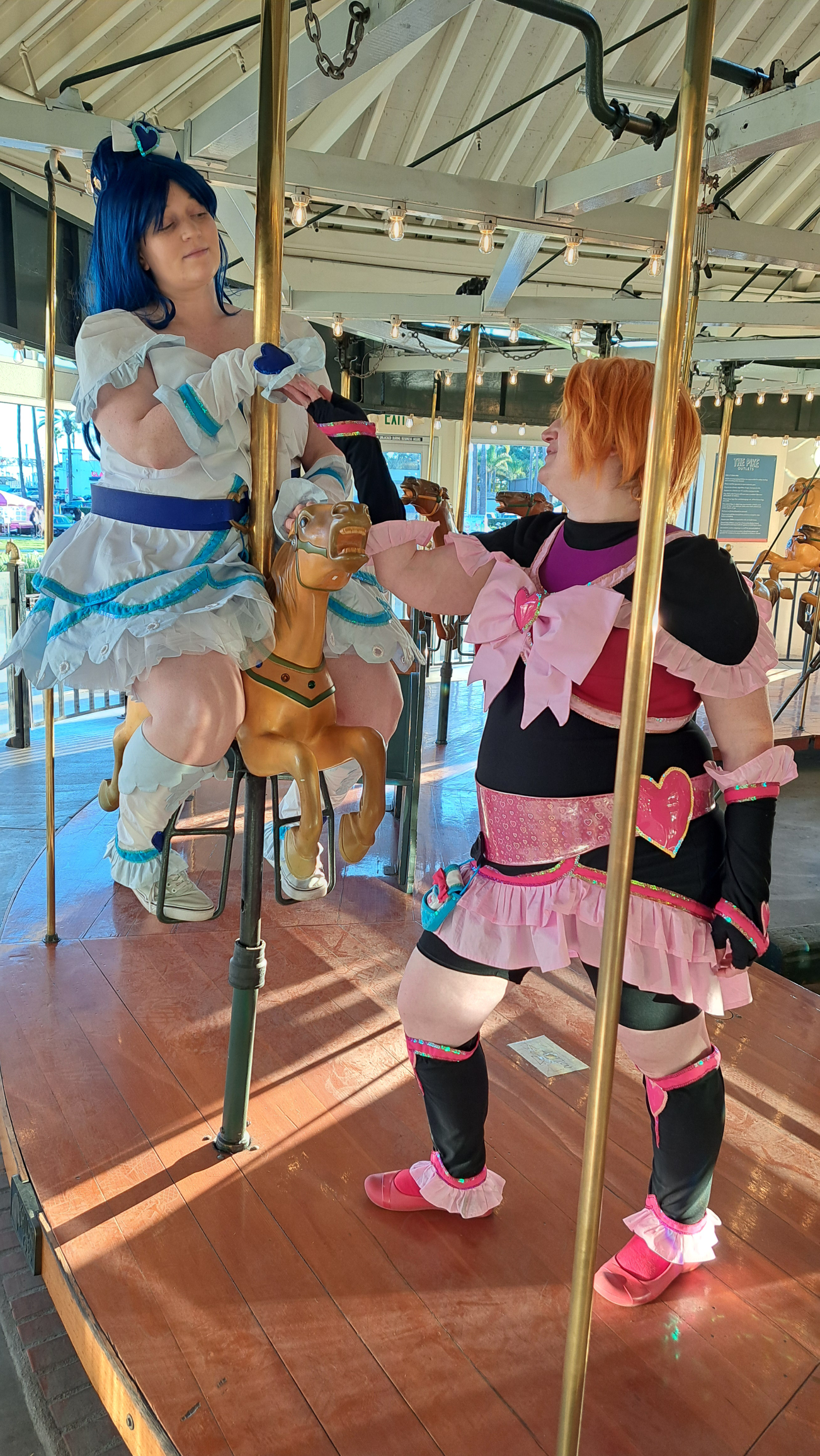 Cure White sitting on a carousel horse while Cure Black reaching out to her like a knight to a princess