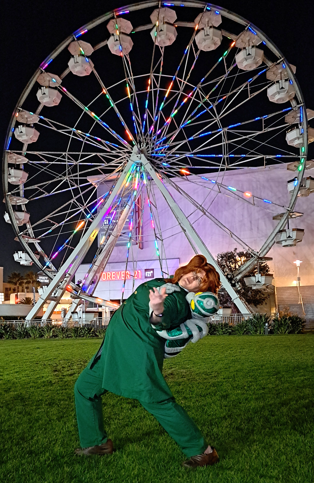Kakyoin leaning backwards in front of a ferris wheel