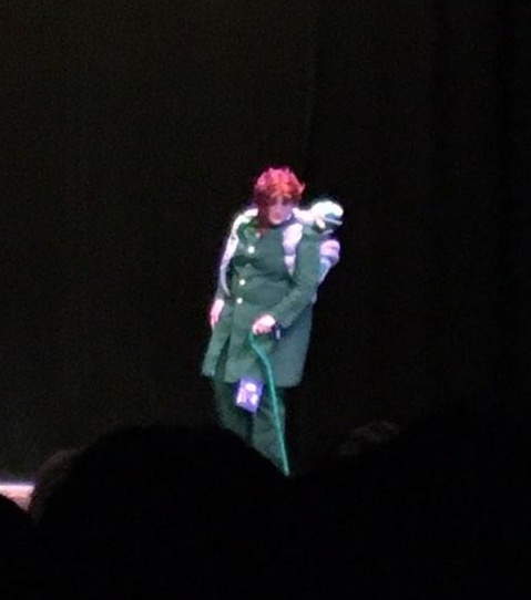 Looking to the side on a dark stage.