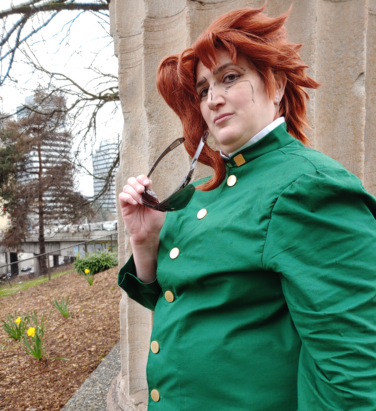 Kakyoin pulling off sunglasses in front of a column