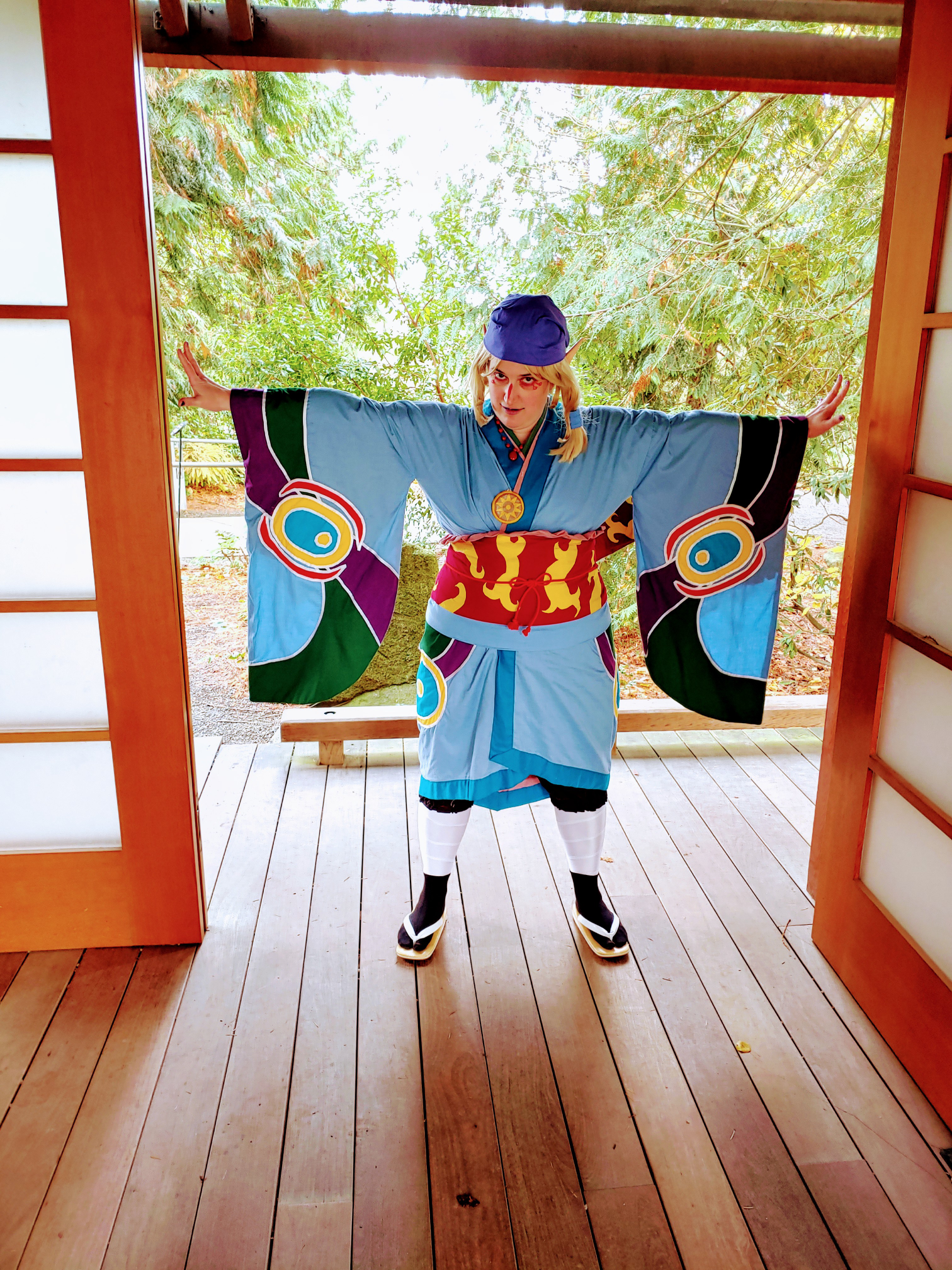 the medicine seller, arms outstretched in a doorway