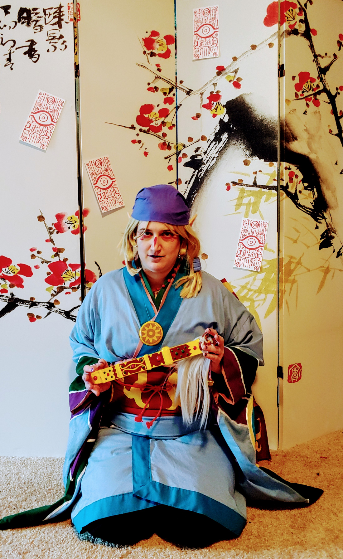 medicine seller kneeling in front of a cherry blossom screen
