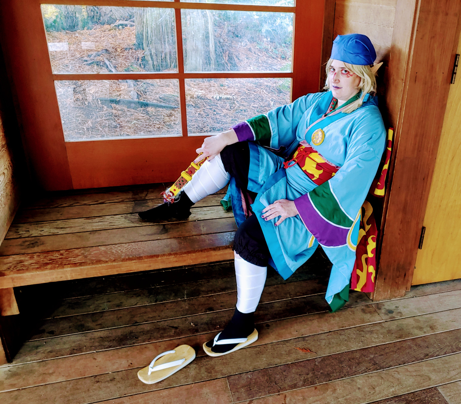 the medicine seller sitting on a bench by a window with one shoe off