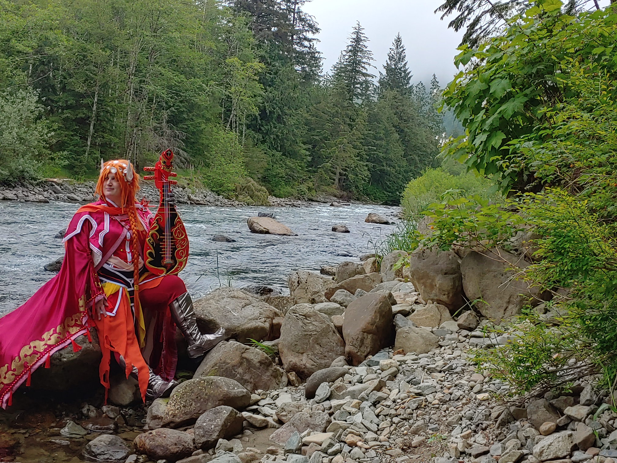 Lang sitting on rocks by a rushing river