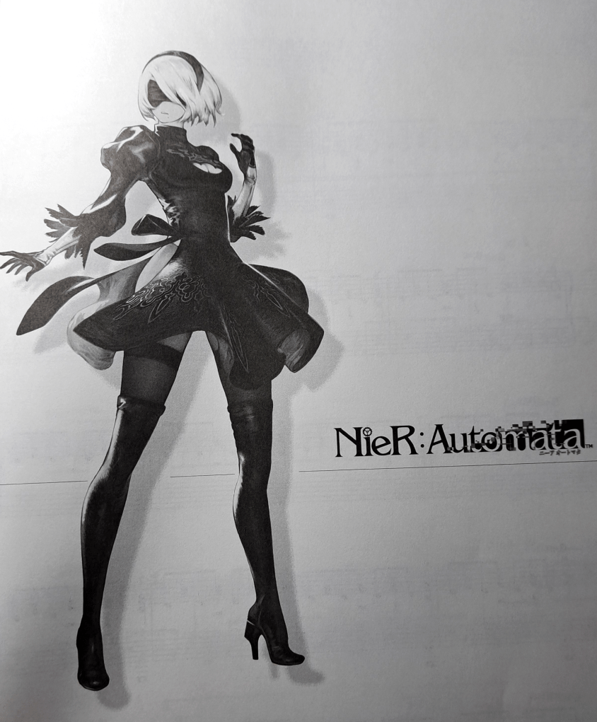 2B standing in front of a white background with NieR:Automata written on the right.