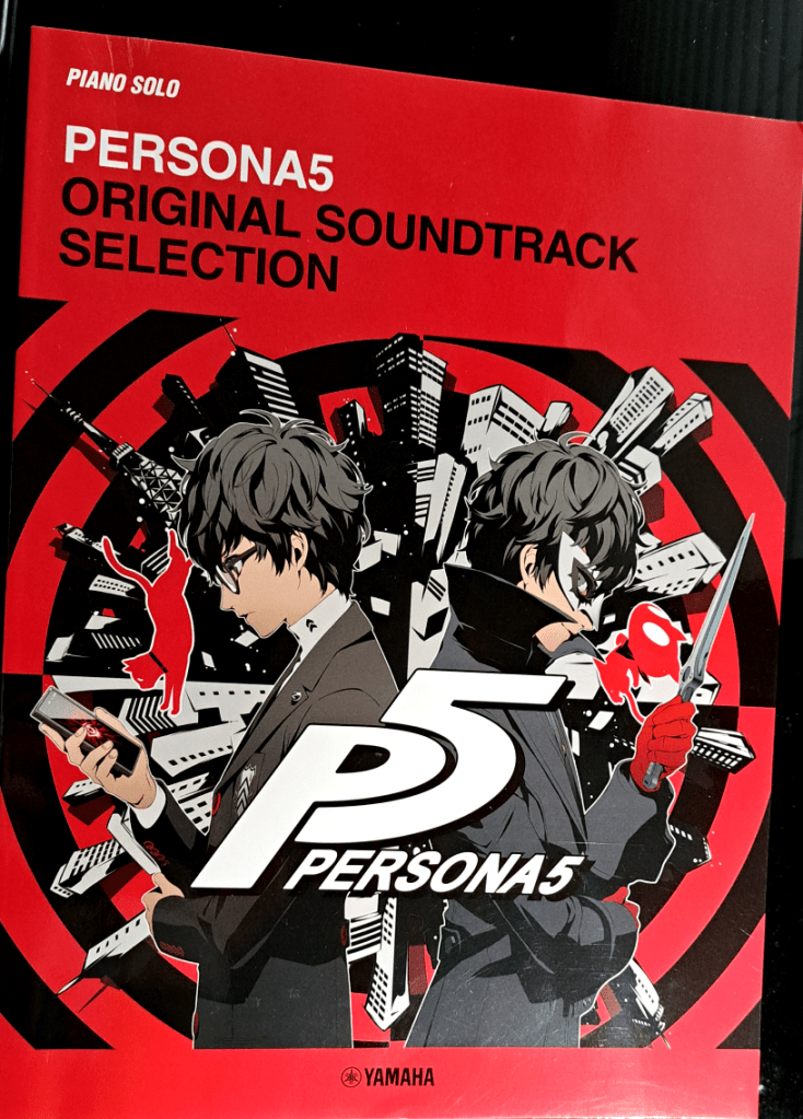 Red front cover. White text reads "Piano Solo Persona5", black text "Original Soundtrack selection. In the middle is the protagonist back to back with Joker with P5 over their shoulders and a black spiral detail behind a circular city