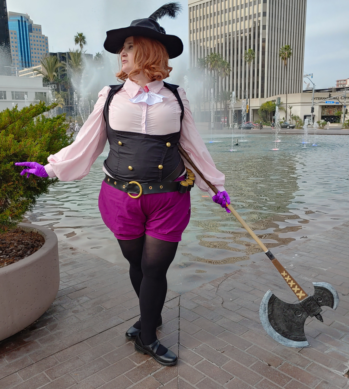 Noir standing in a ballet 5th position with axe outstretched to the right