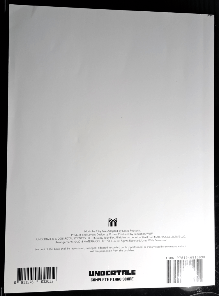 Back cover almost completely white. The credits are in small print above the barcode and title, "Undertale Complete Piano Score"