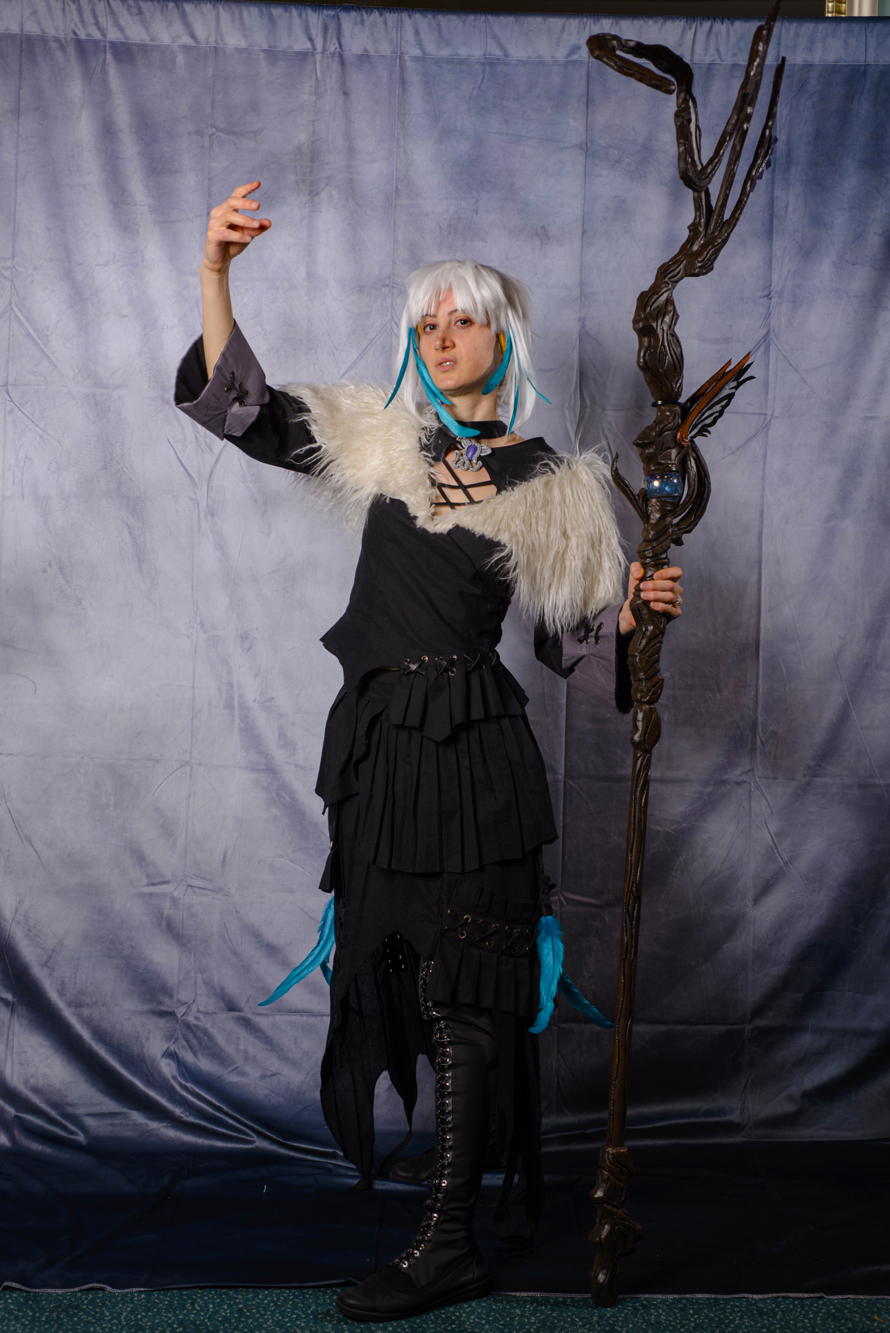 Y'shtola standing in front of a gray curtain, facing forward