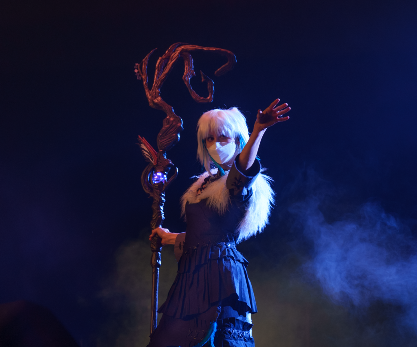 Y'shtola on stage with dramatic lighting from the back, arm outstretched