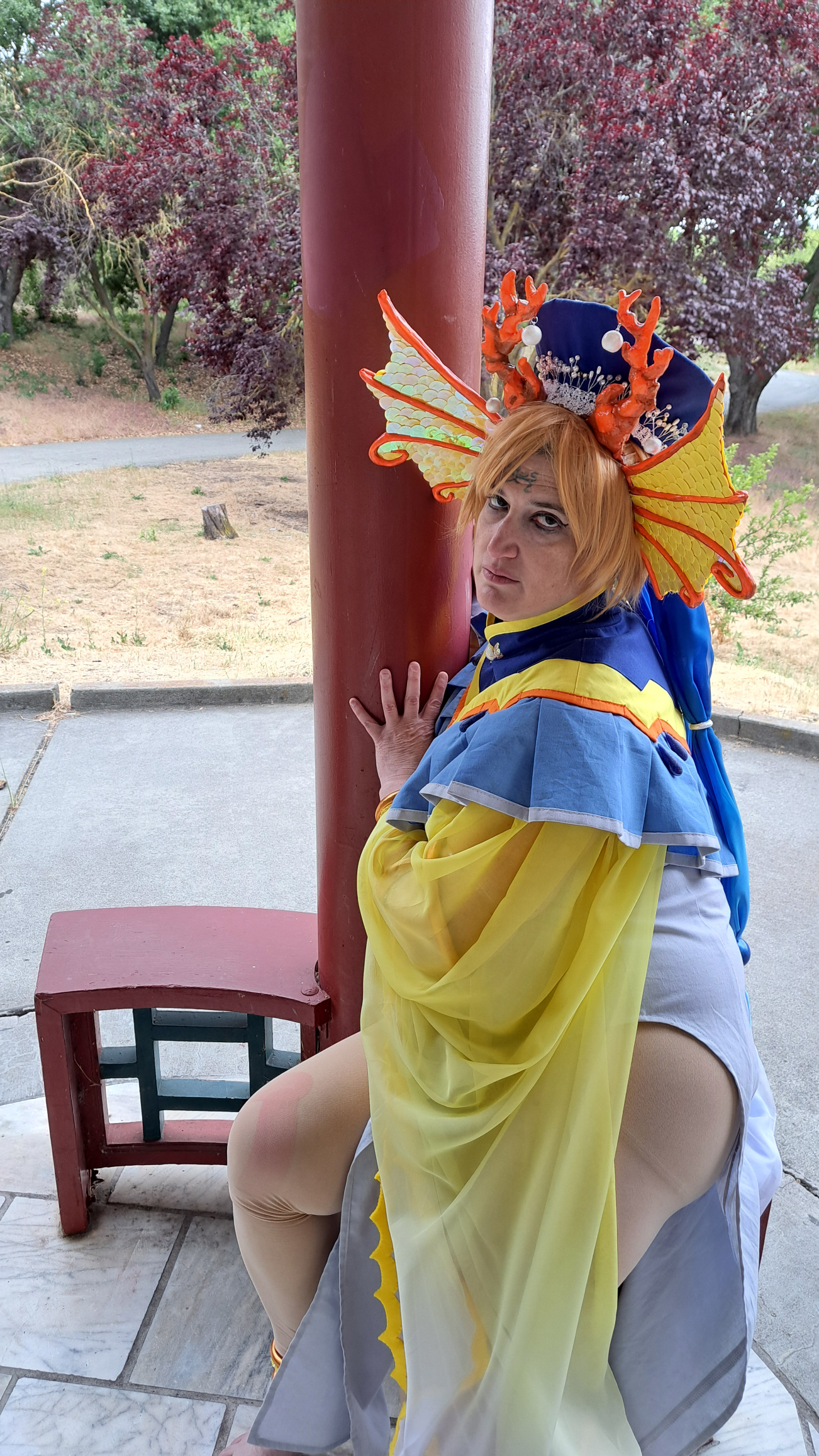 Yui looking over her shoulder, leaning against a reddish column