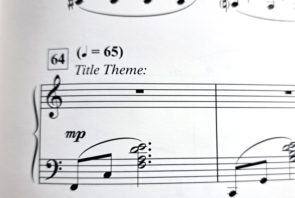 Grand staff with notes. In parenthesis, time marker is "quarter note = 65" and staff text reads "Title Theme:"
