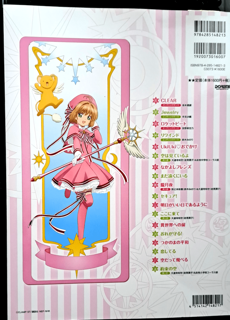 Back cover featuring Sakura in her pink dress with red and white striped ribbons with Kero to her left. To the right is the list of all the songs in the book (refer to the Song List section above) written in alternating pink and green. The background is pink and white stripes with white spell circles.