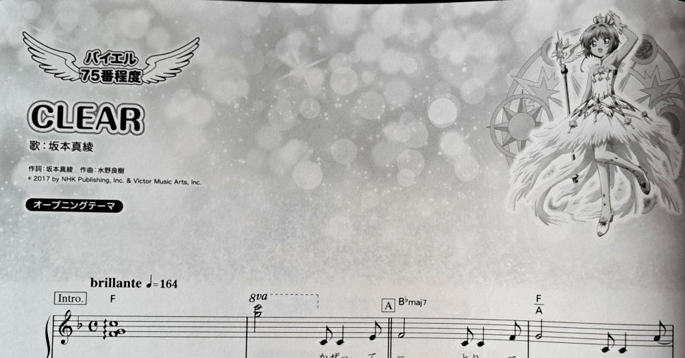 Title decorations for the song "CLEAR", written on the left, with Sakura in her opening white and gold dress on the right against a background of white puffy sparkles.