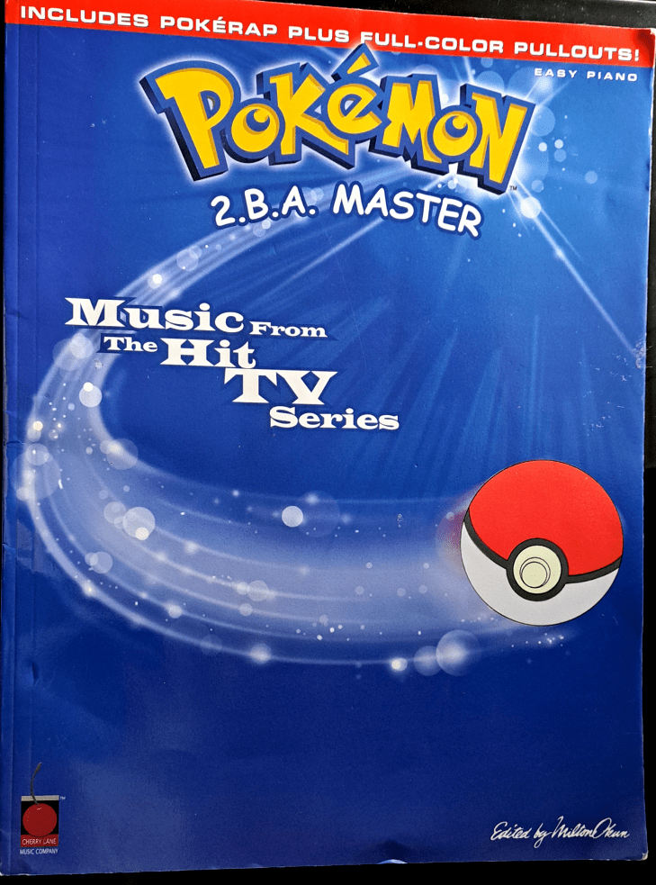 Blue front cover with a red banner across the top that says "Includes PokeRap plus full-color Pullouts!" Below that is the yellow "Pokemon 2.B.A. Master" logo then "Music from the Hit TV Series". A pokeball wooshes forward from the left to the right.