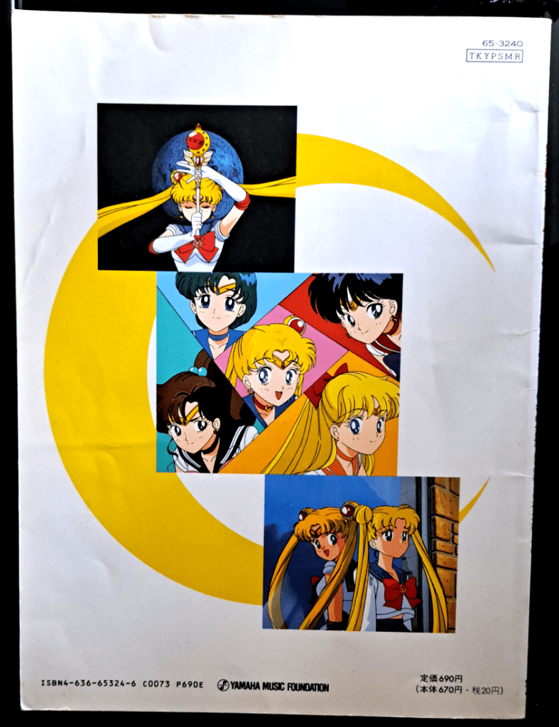 Back cover. White background with a giant crescent moon. Top screenshot is Moon using the Cutie Moon Rod. Middle screenshot is all 5 guardians together in angular shapes with their theme color behind them. Bottom is Usagi leaning against a window with Moon looking over her shoulder back at her.
