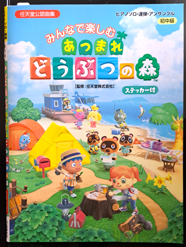 Front cover. The title says "Animal Crossing: New Horizons" in colorful Japanese. The front cover includes the villager and residents camping and arriving on the beach from a water plane.