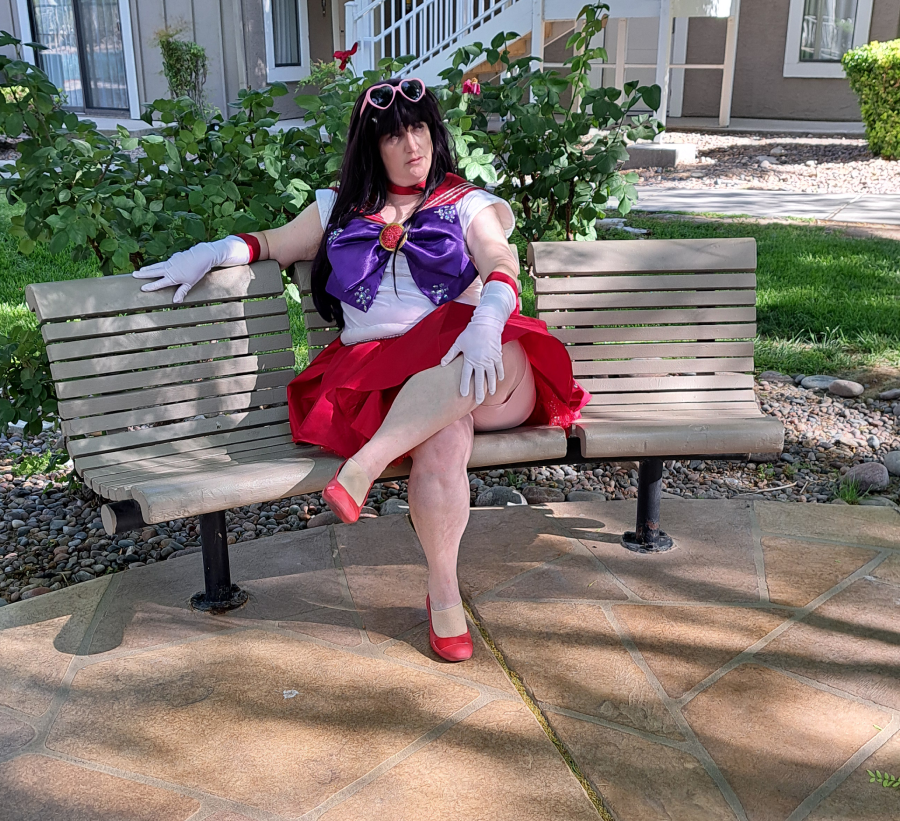 Mars sitting on a bench, pink heart-shaped sunglasses on head, waiting