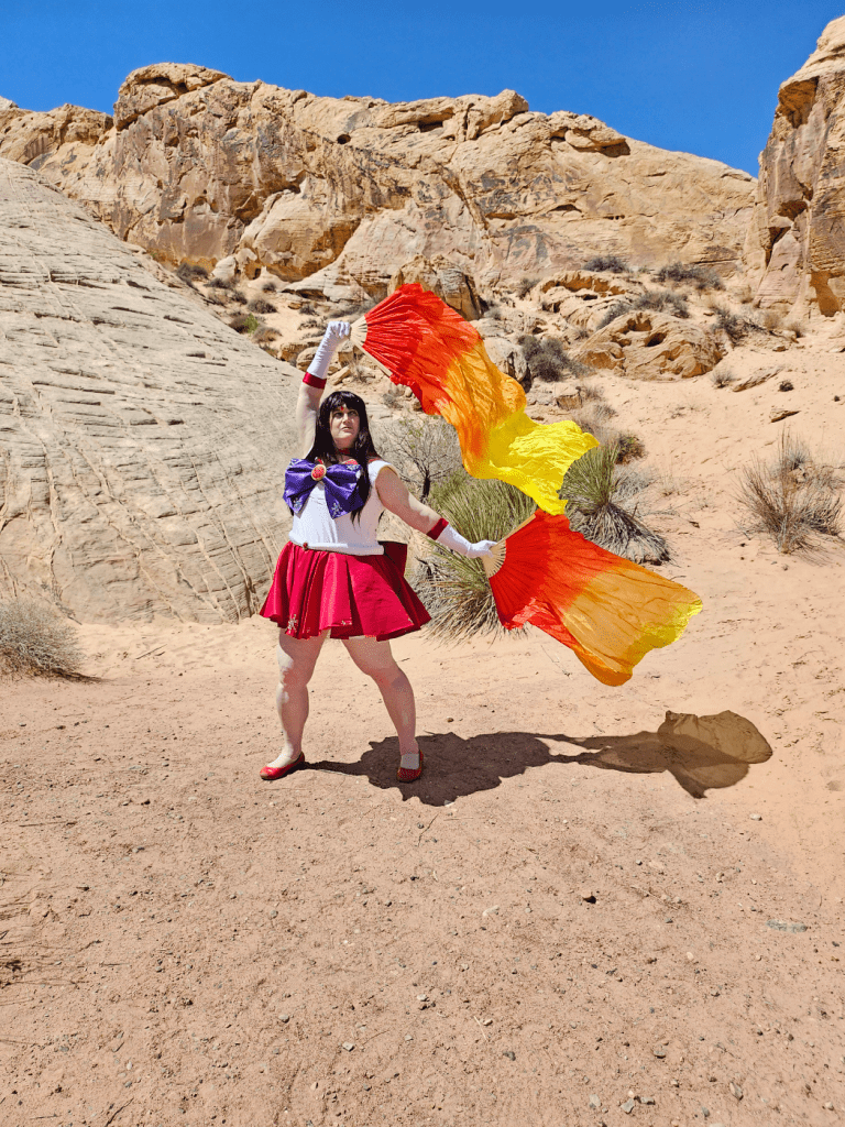 Mars with fire silks flying off to the right in front of rolling rocky hills