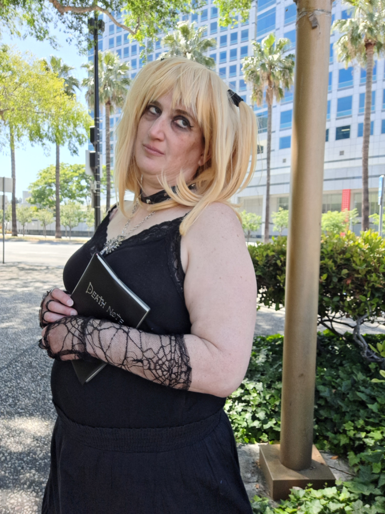 Misa with death note in arms, folded over midsection, looking off to the side like she's plotting something