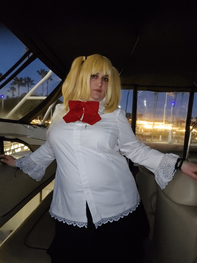 Misa standing in a dark room with a bright background seen through the window