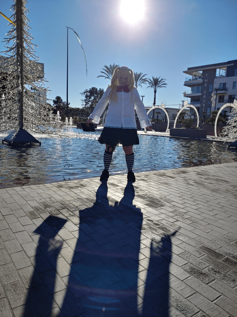 Misa standing stiffly with the sun behind, casting a long shadow on the ground